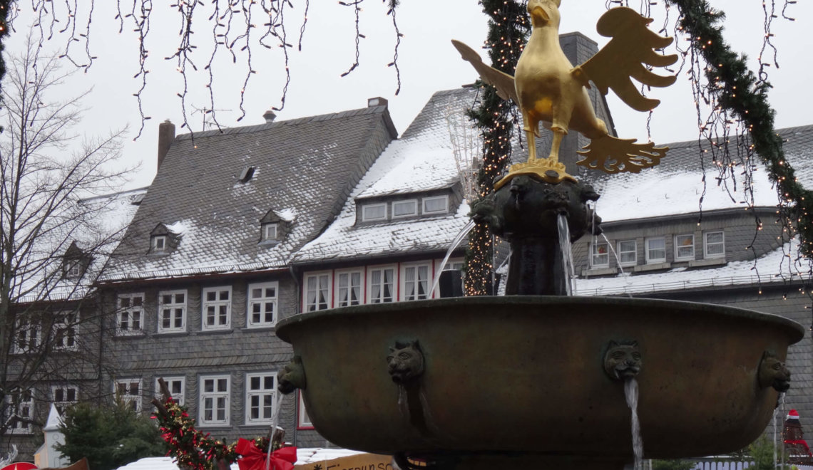 De keizerlijke adelaar op een fontein tussen kerstslingers en besneeuwde huizen