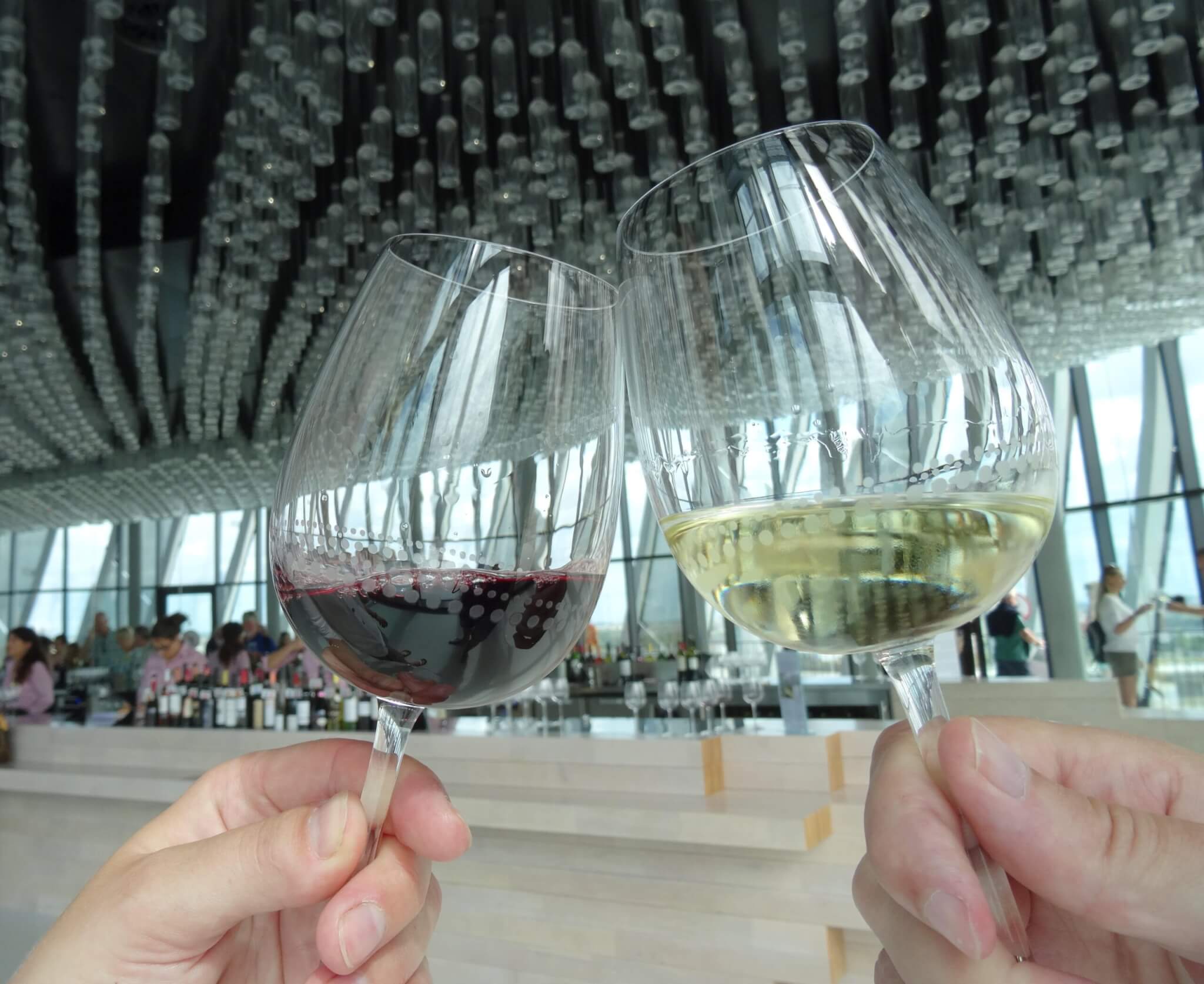 Proosten met glas rode en witte wijn in La Cité du Vin Bordeaux