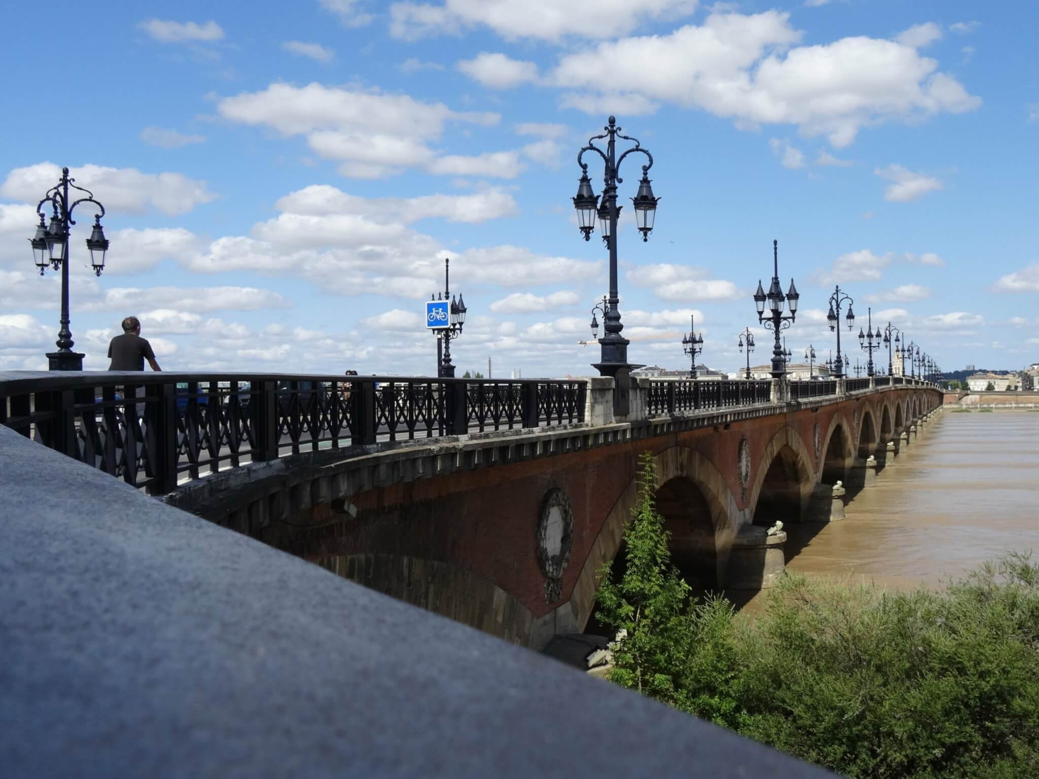 Brug Pont de Pierre heeft zeventien bogen over modderige Gardonne en gietijzeren straatverlichting