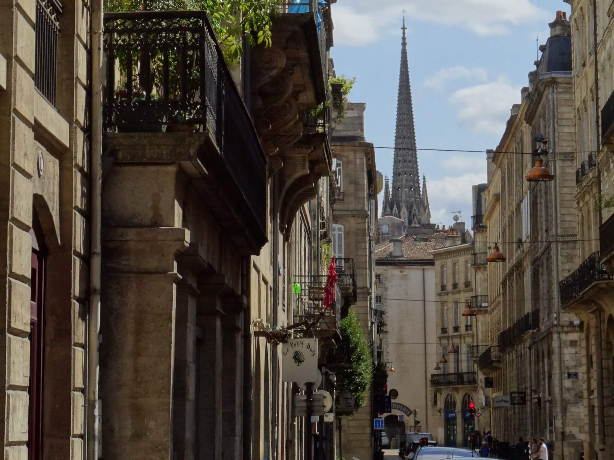 Straatbeeld Bordeaux met klassieke gevels, Franse balkons en gotische kerkspits aan de einder