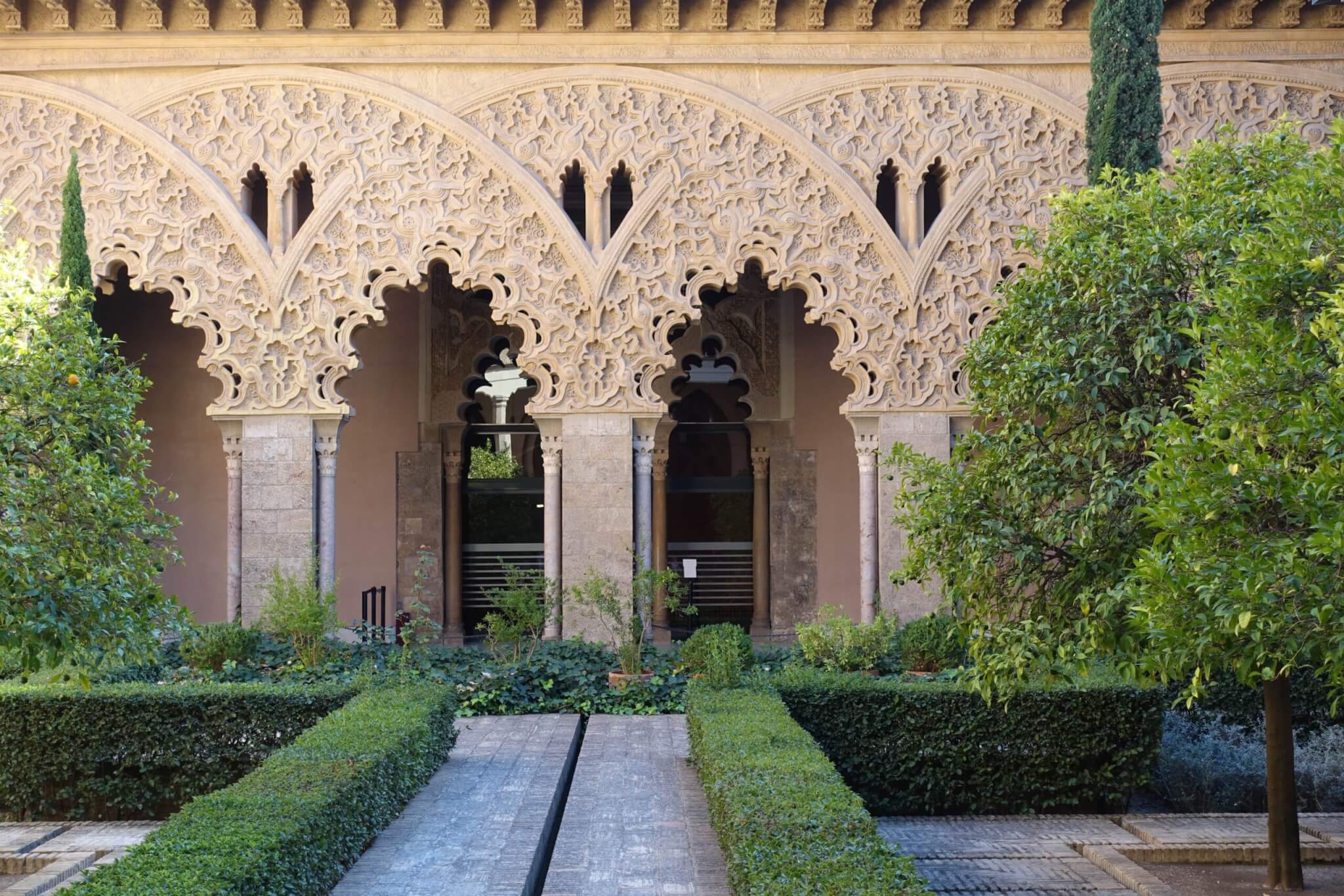 In elkaar overlopende bogen van Mudejar arcade rijkelijk versierd met kronkelend pleisterwerk