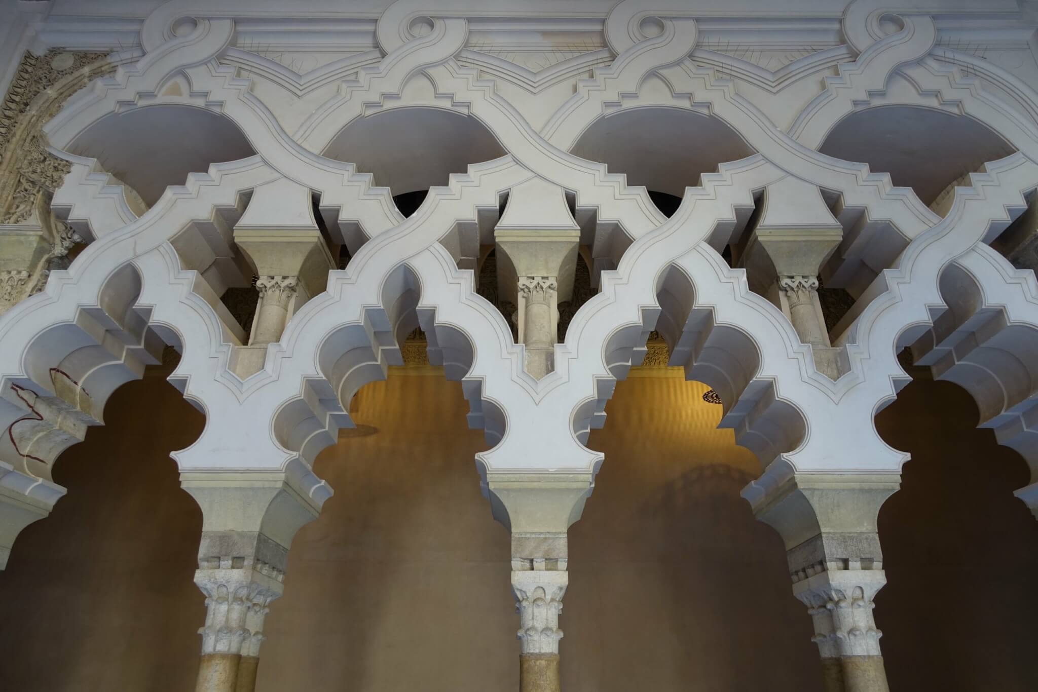Complexe in elkaar verweven en doorlopende bogen rustend op smalle zuilen in paleis Aljaferia