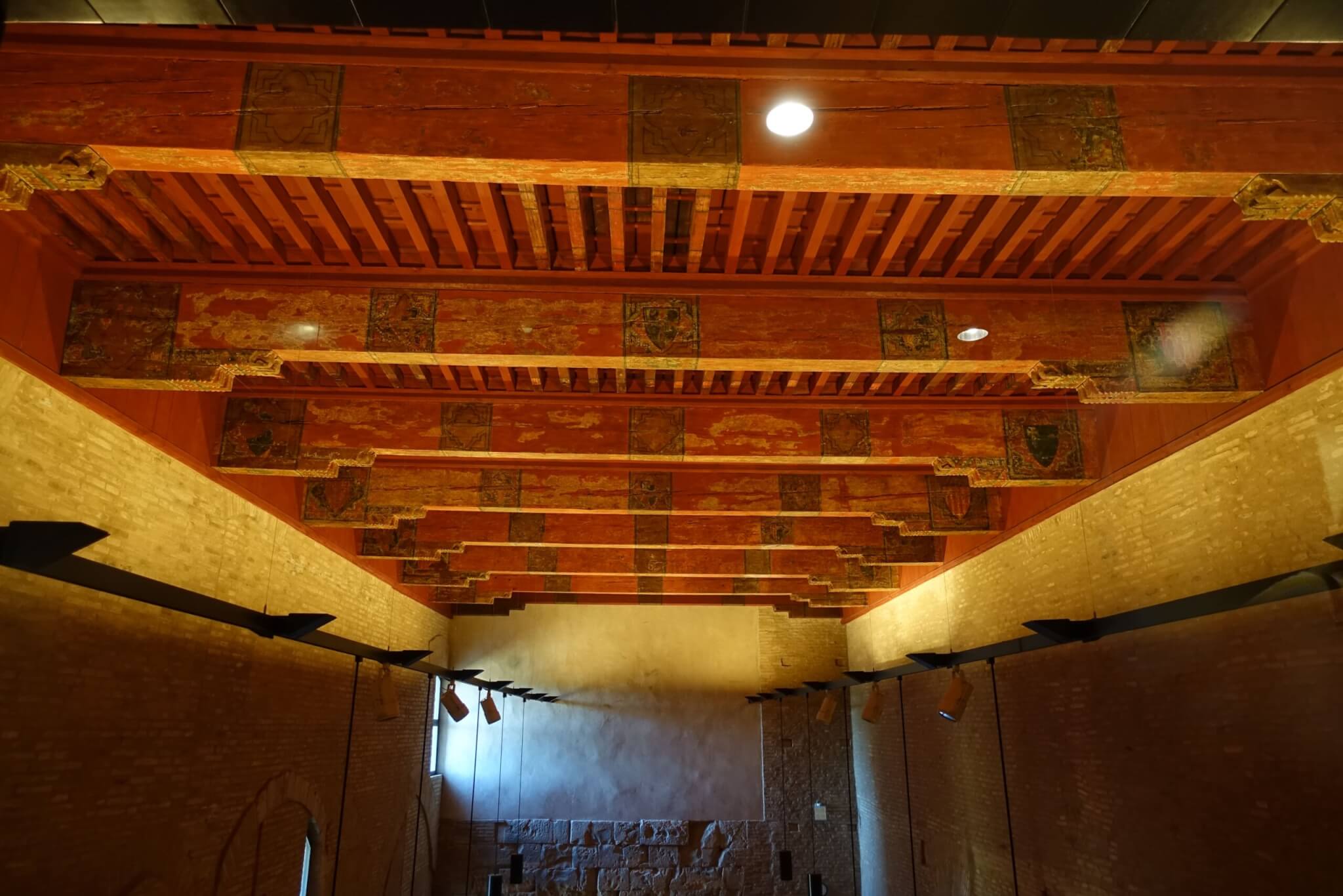 Houten plafond met vele dwarsbalken overdekt ruimte in paleis Aljaferia