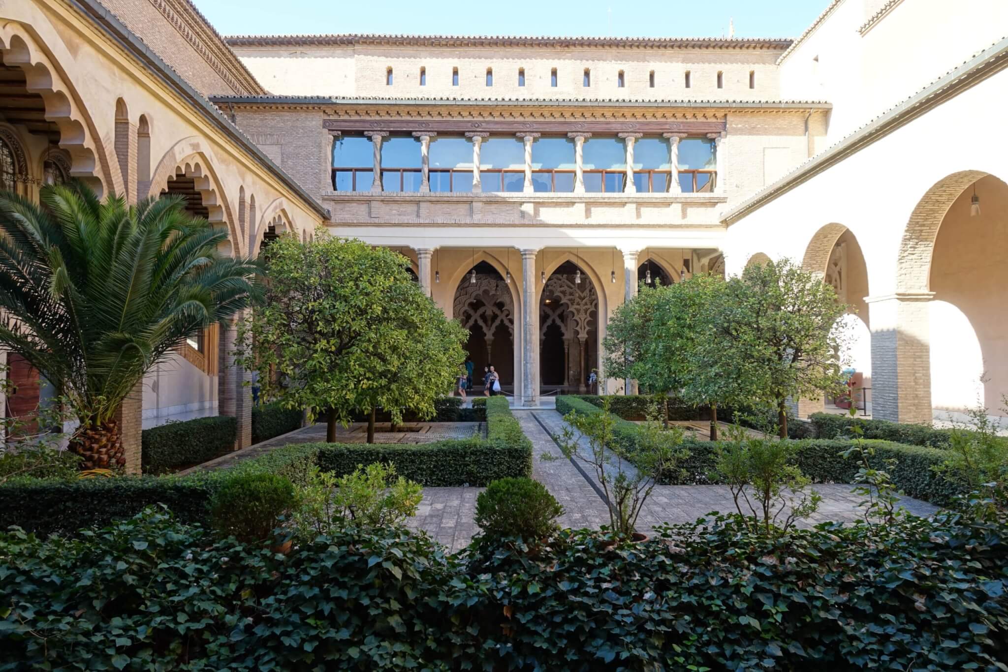 Binnenhof Aljaferia met buxushagen fruitbomen en door arcaden omringd