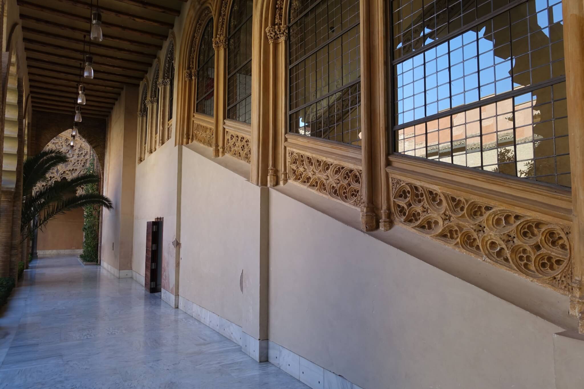 Buitenzijde trap met gotische decoratie op balustrade en boogvensters met glas