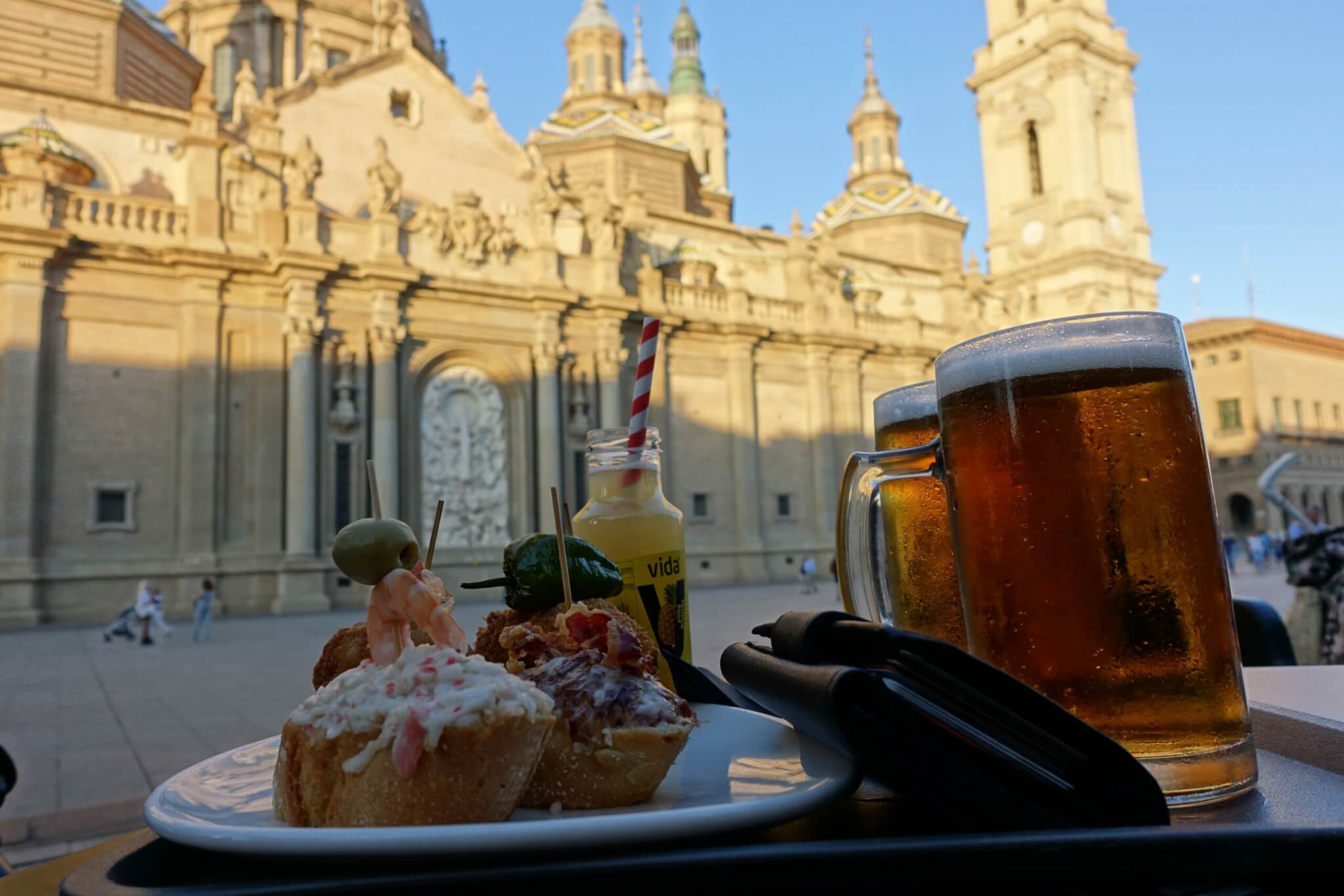 Pintxos en pullen bier met op de achtergrond de kathedraal van Zaragoza