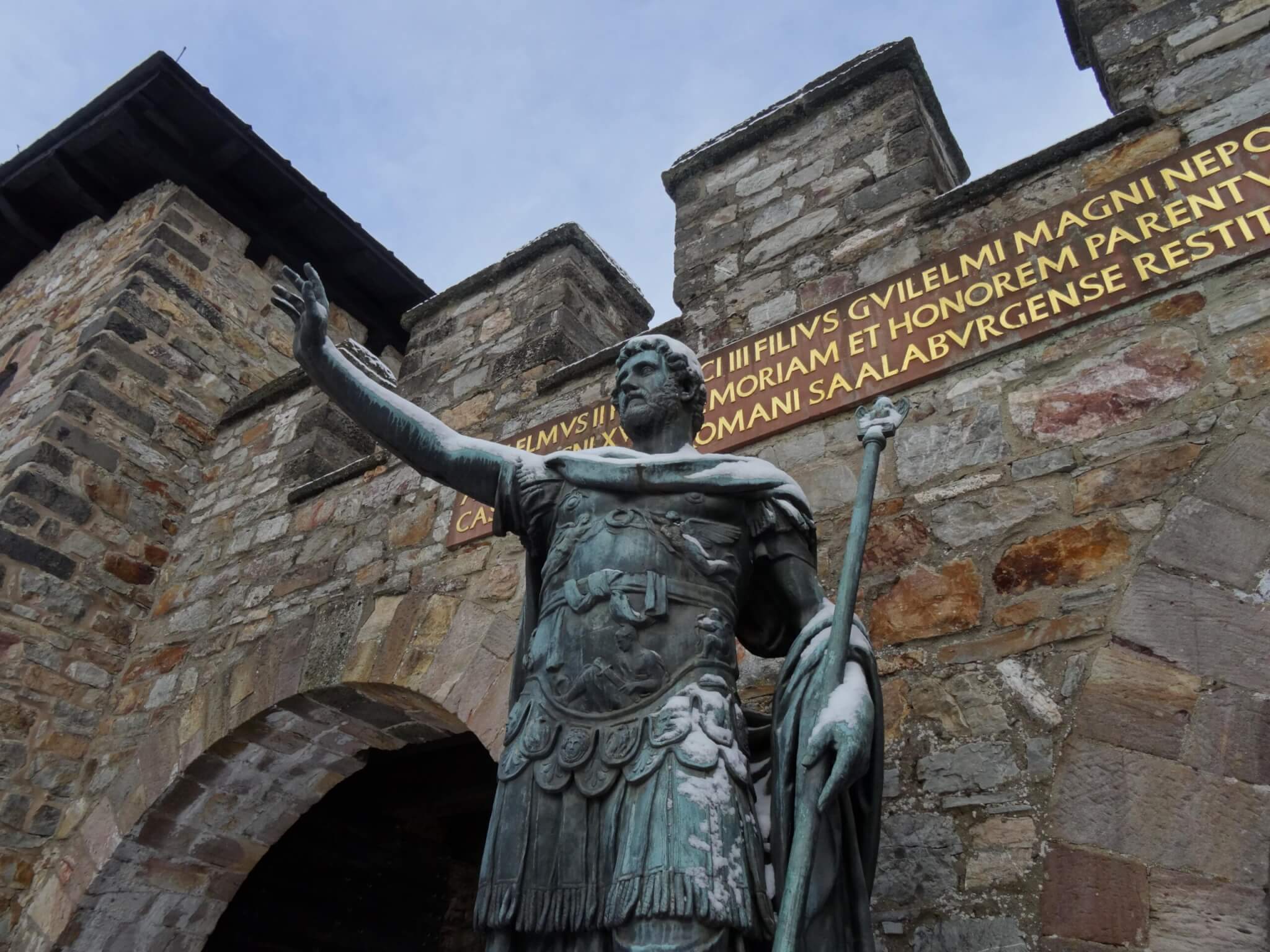 Keizer Antonius Pius in Romeins legeroutfit met geheven hand voor de hoofdpoort fort Saalburg