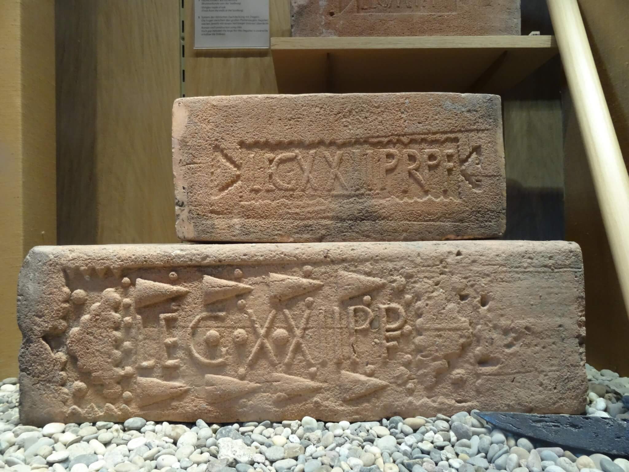 Twee op elkaar gestapelde stenen met een Romeins legioensstempel