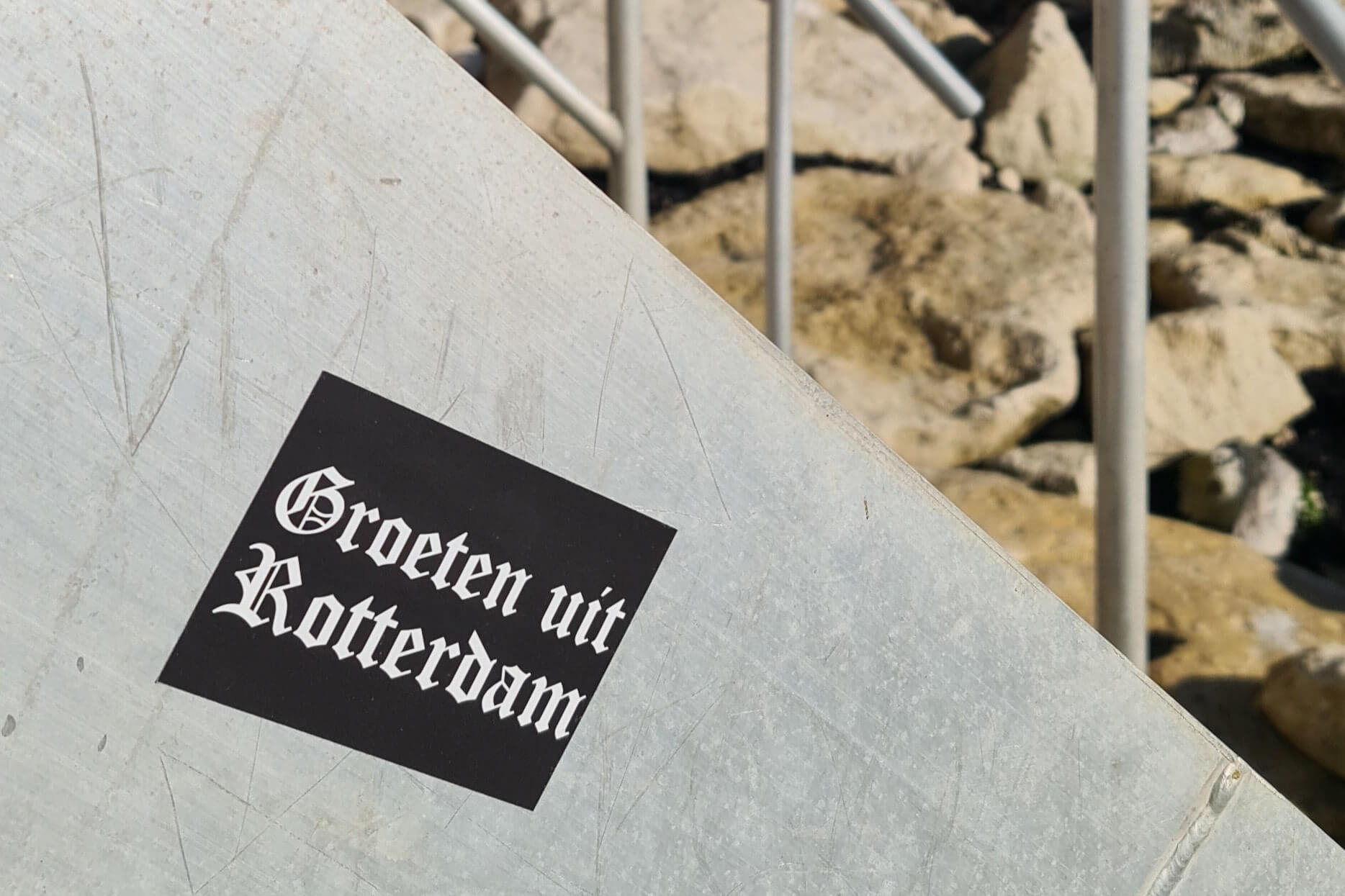 Zwart-witte sticker met tekst: Groeten uit Rotterdam op zijkant trap