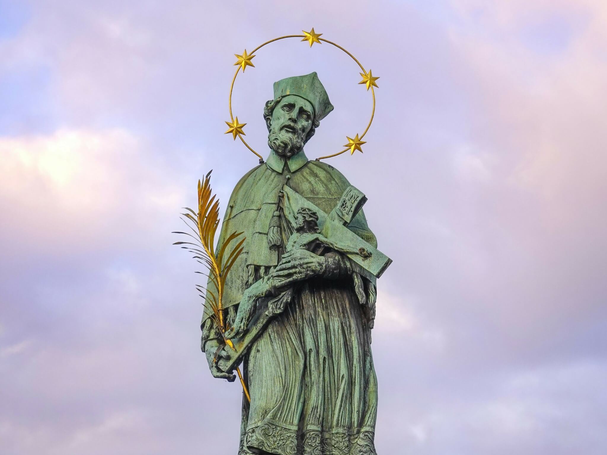 Standbeeld van Johannes Nepomuk met vijf sterren rond zijn hoofd en een kruisbeeld en palmtak in zijn handen