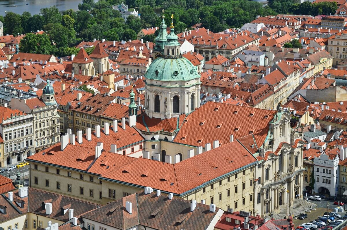 Bovenaanzicht op barokke Sint-Nicolaaskerk met grote koepel te midden van oude bebouwing 