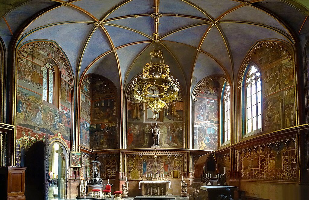 Sint-Wenceslaskapel in Sint-Vituskathedraal met gouden kroonluchter en kleurrijke fresco's die het leven van de heilige uitbeelden