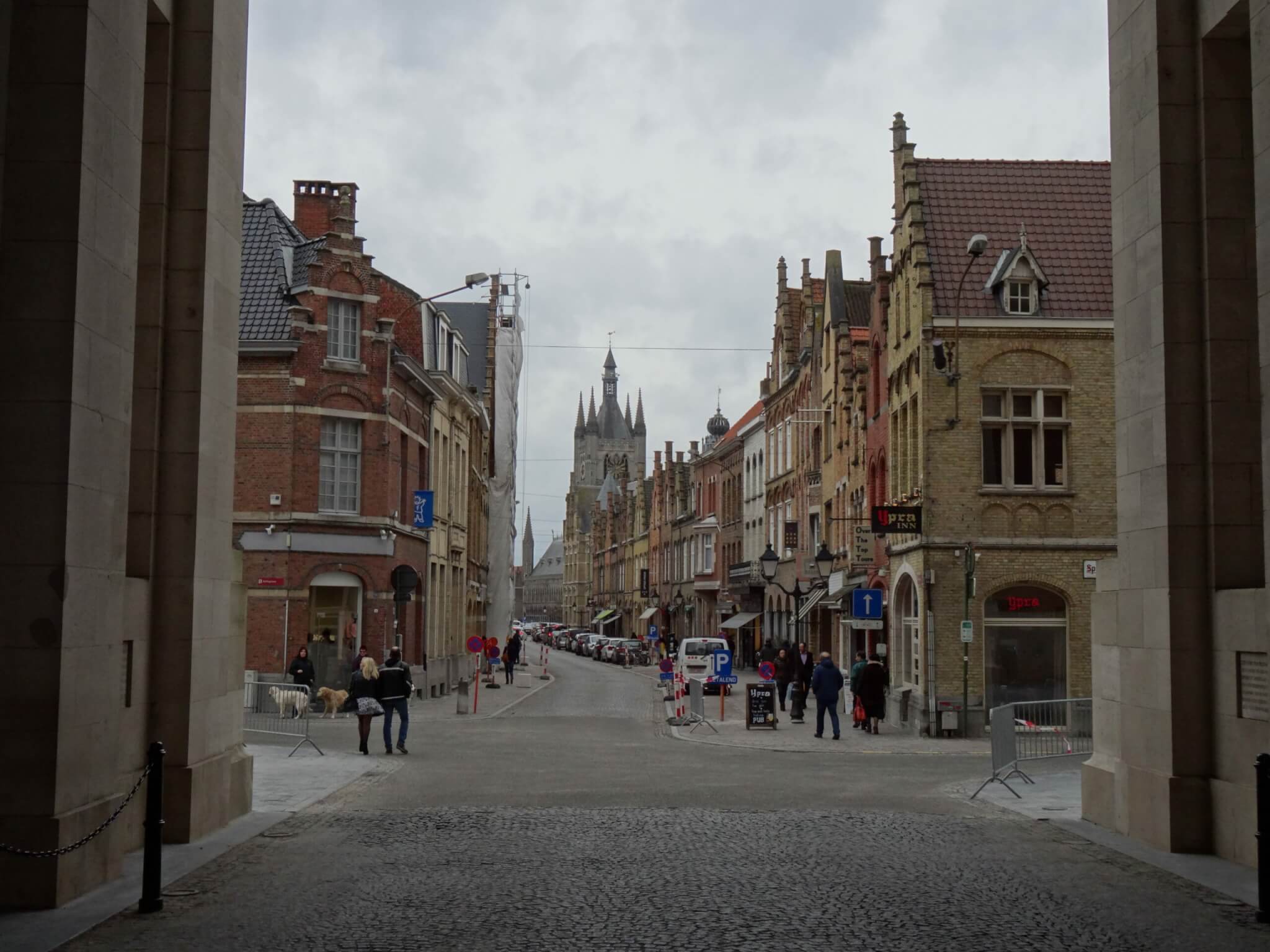Zicht op een winkelstraat in Ieper vanonder de Menenpoort richting Lakenhal